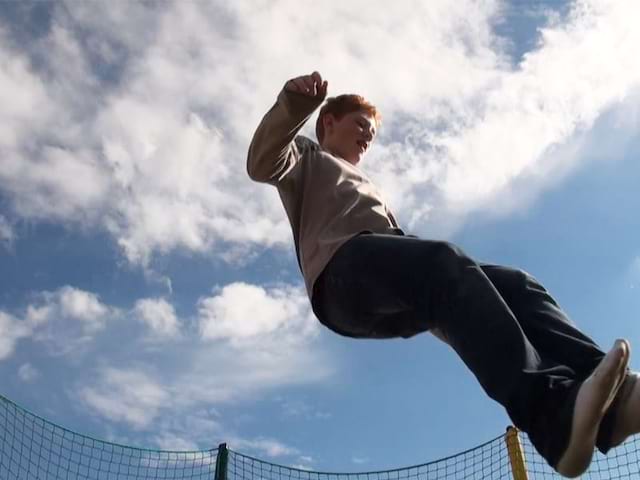 Ado sautant dans les airs en trampoline en colonie de vacances