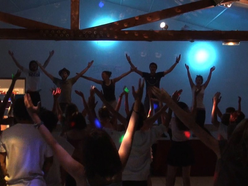 Groupe d’enfants en boom en colonie de vacances dansant avec leurs animateurs de colo été