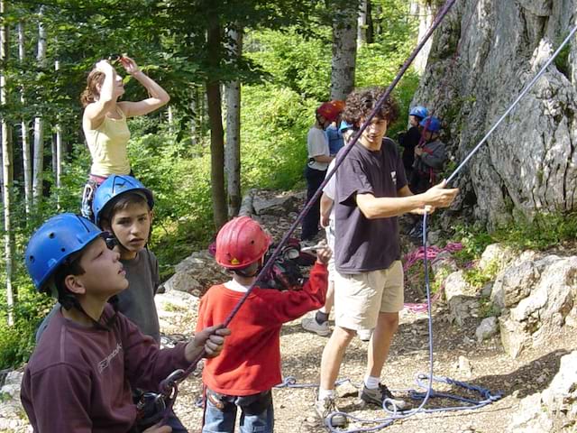 Enfants apprenant à faire de l'escalade sur voies naturelles en colonie de vacances été 