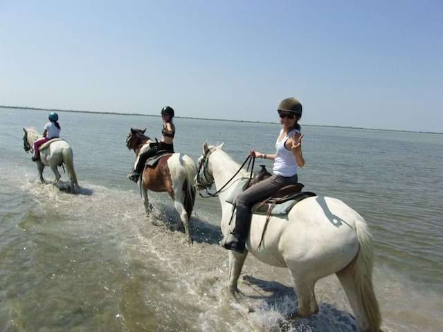 Enfants en balade à cheval en bord de mer en colo équitation