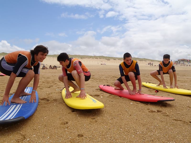 Adolescents apprenant à se positionner sur une planche de surf en colonie de vacances d'été