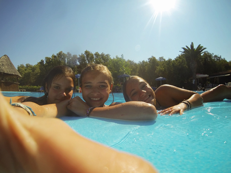 Groupe de preados en colonie de vacances se baignant à la piscine