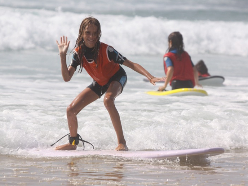 Jeune fille faisant du surf en colonie de vacances à l'océan atlantique