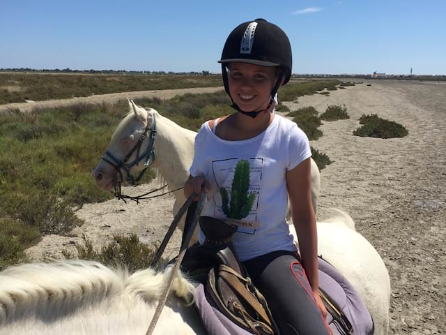 Fillette en balade à cheval en colonie de vacances en Camargue