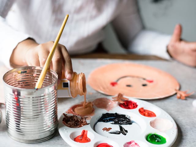 Enfant faisant des mélanges de peinture en colonie de vacances artistique été