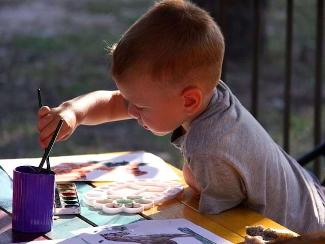 Enfant faisant des dessins en colo