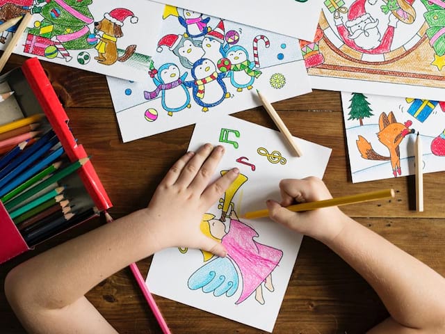 Enfant faisant des coloriages en colo cet été