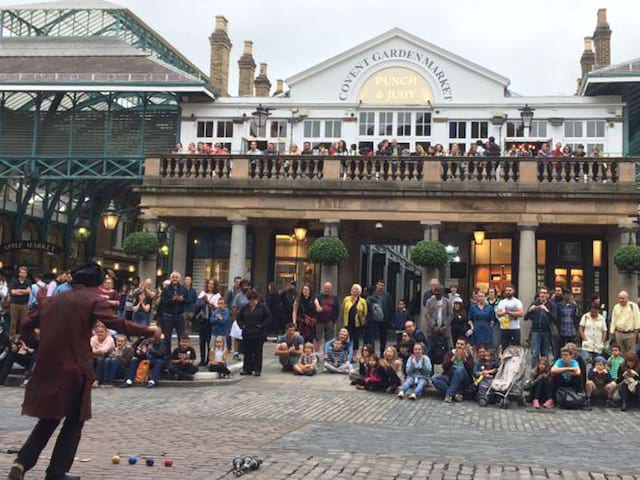 Un groupe d'adolescent regarde un spectacle de rue devant le Covent Garden Market à Londres en Angleterre