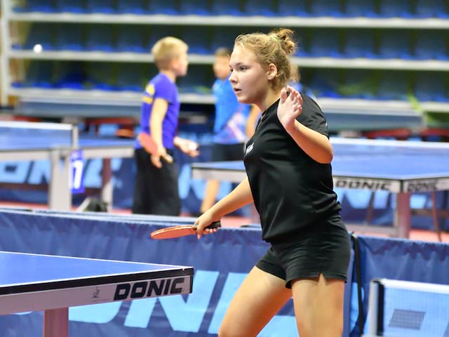 Jeune fille jouant au tennis de table à haut niveau durant un stage sportif 