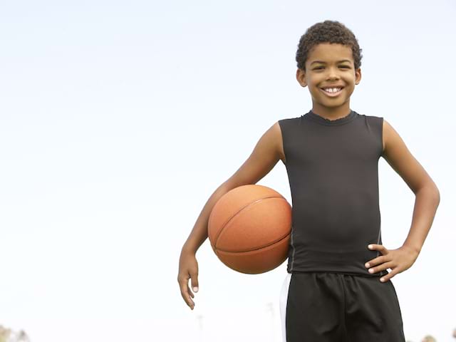 Portrait d'un jeune garcon faisant de basket en stage sportif