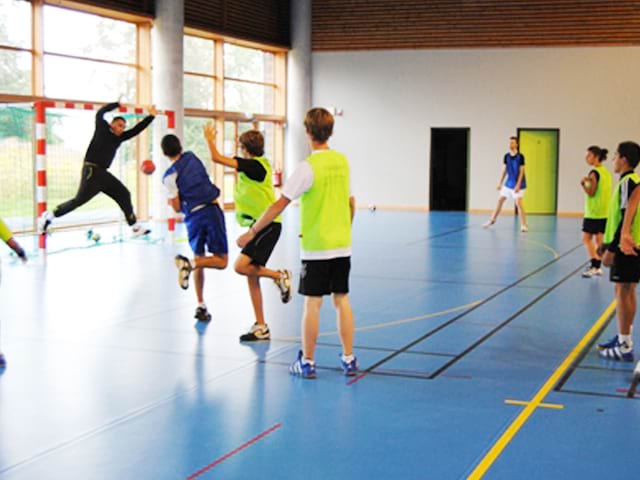 Enfants en entrainement de foot dans un gymnase pendant un stage sportif