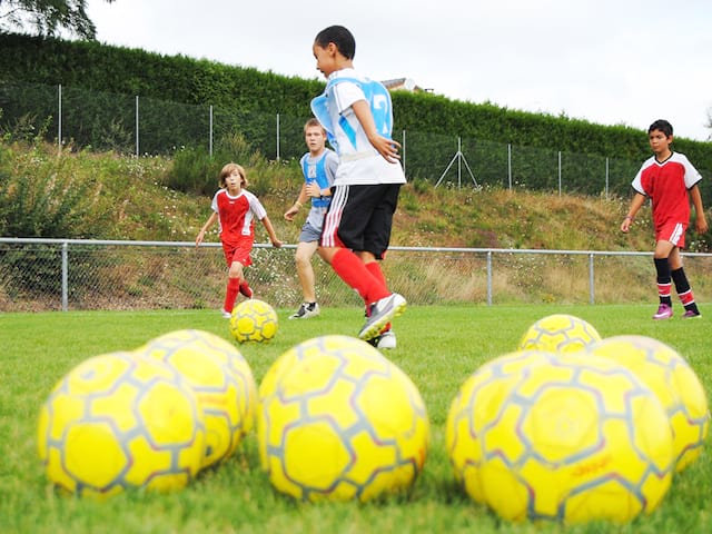 Enfants jouant au football cet été durant un stage sportif de football 