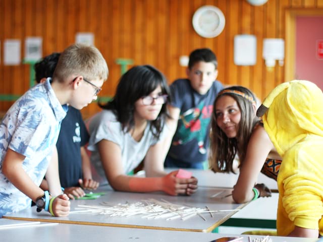 Enfants apprenant à parler anglais entre eux durant un stage sportif