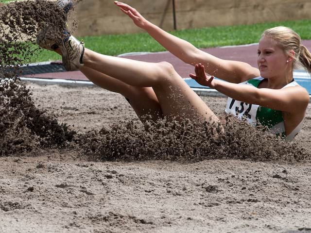 Jeune fille pratiquant le saut en longueur durant un stage athlétisme cet été