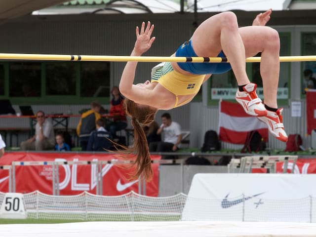 Adolescente pratiquant le saut en hauteur cet été durant un stage sportif athlétisme