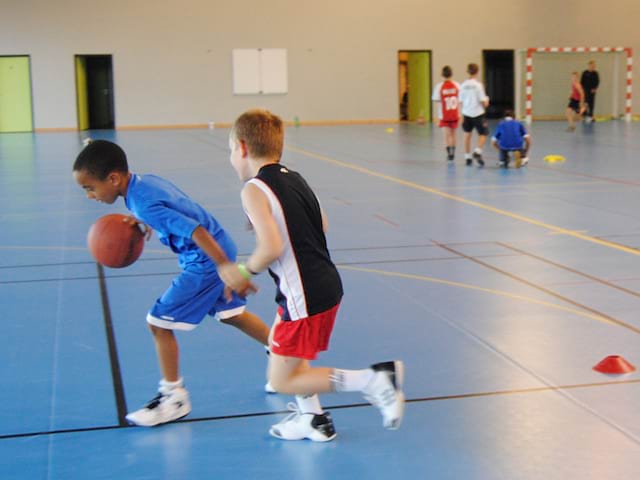 enfants jouant au basketball en colonie de stage sportif basket