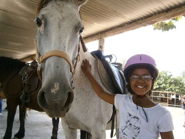 Portrait d'une enfant avec son cheval de stage sportif été