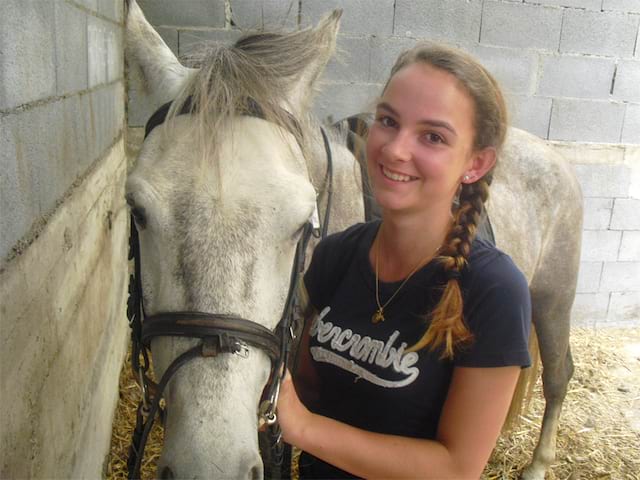 Portrait d'une jeune fille avec son cheval en colonie de vacances équitation