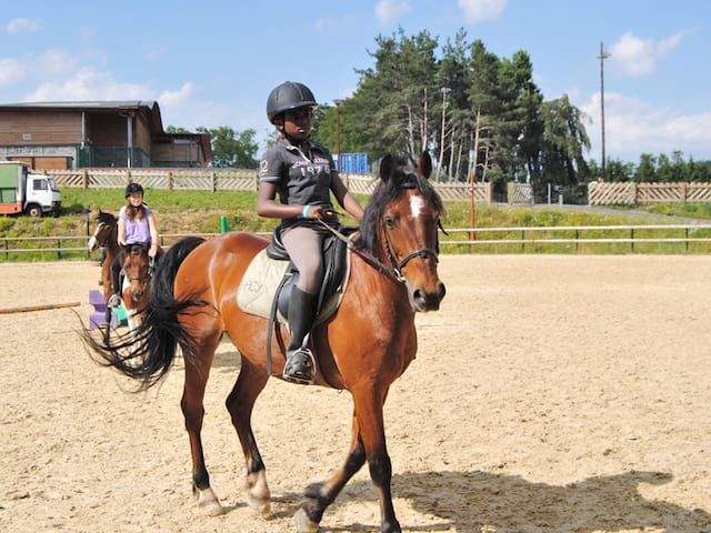 adolescente sur un cheval en stage sportif équitation été