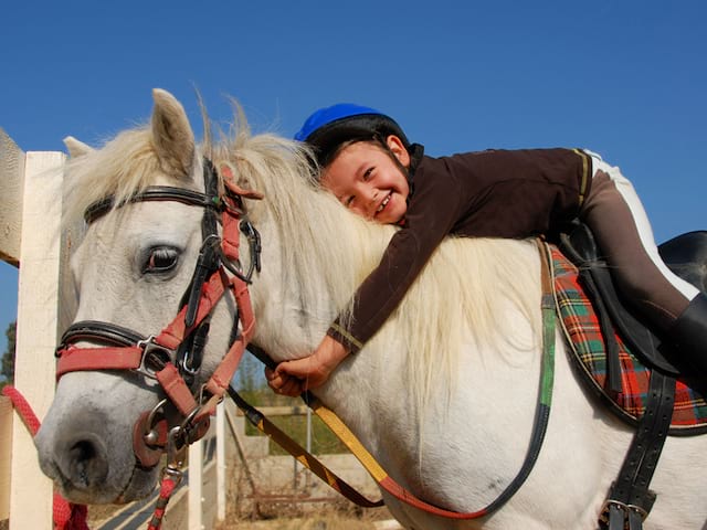 Enfant à dos de cheval en stage sportif équitation été