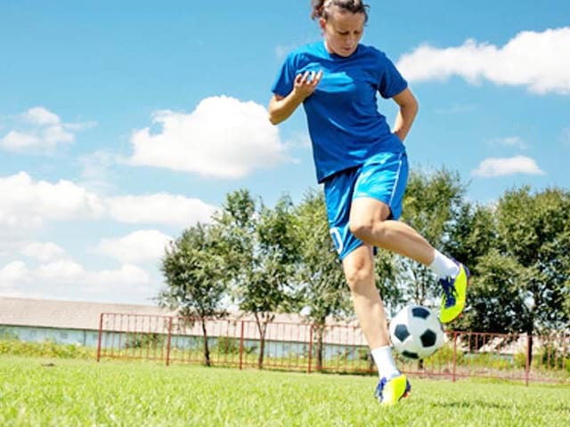 Ado jouant au football en stage de football cet été