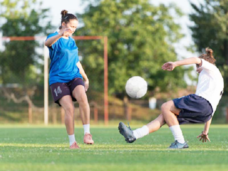 Adolescents jouant au football en stage sportif