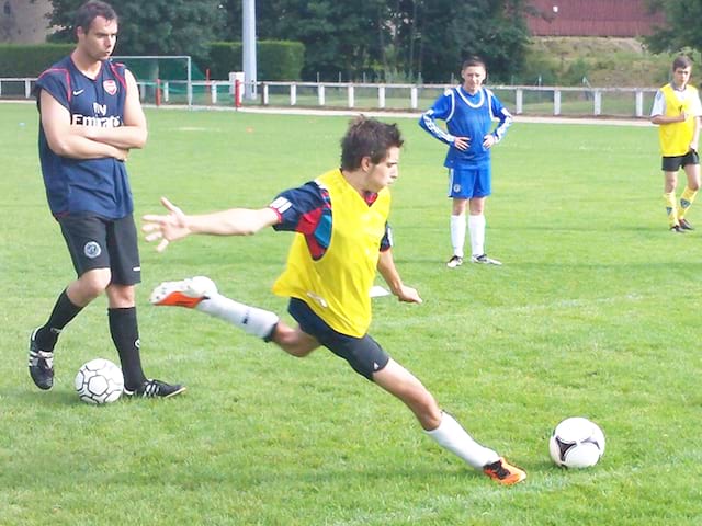 Adolescent jouant au football en stage sportif cet été