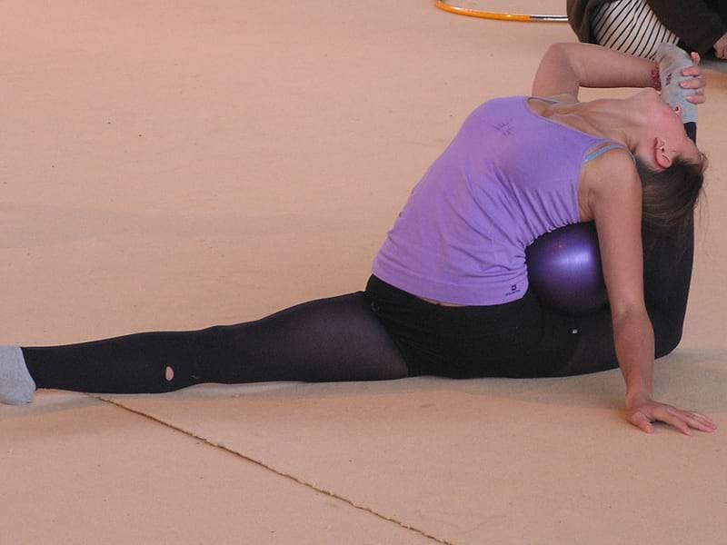 Jeune fille faisant des étirements en stage de gymnastique cet été