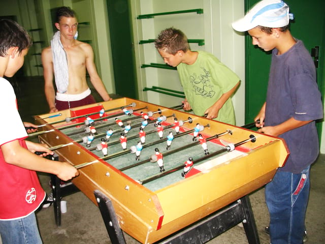 adolescents jouant au babyfoot pendant les temps libres de stage sportif