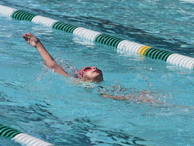 Enfant s'entrainant à nager à la piscine du centre de stage sportif de natation de cet été