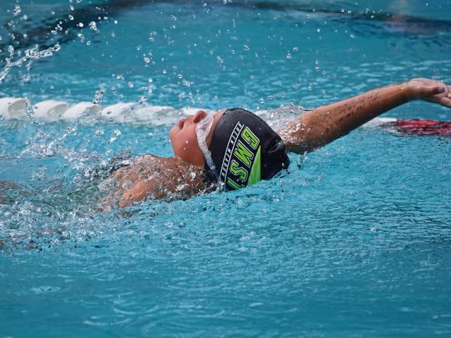 Enfant apprenant à nager durant un stage sportif de natation cet été