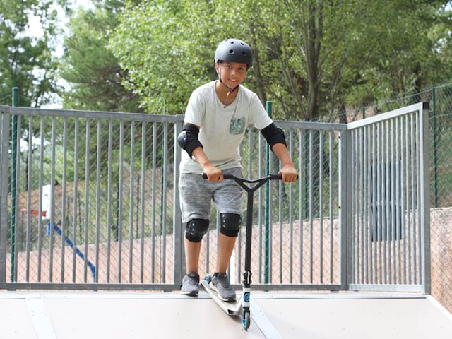 Adolescent faisant du skateboard et roller en colonie de vacances d'été