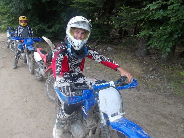 groupe d'ados faisant de la moto dans les bois en stage sportif cet été