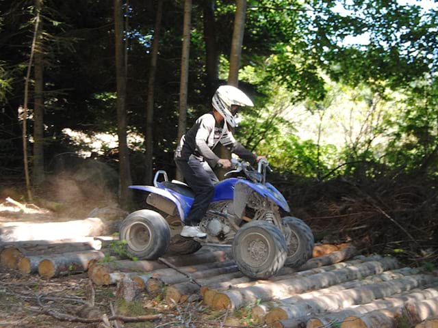 enfants apprenant à passer des obstacles avec un quad durant un stage sportif dédié aux sports mécaniques