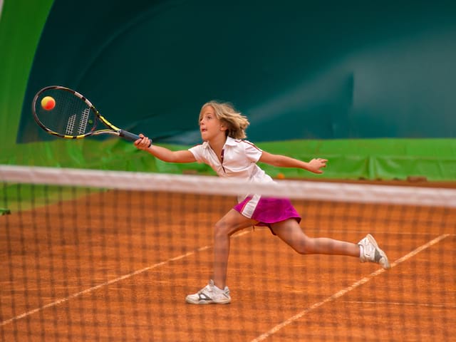 jeune fille participant à un stage sportif de tennis cet été