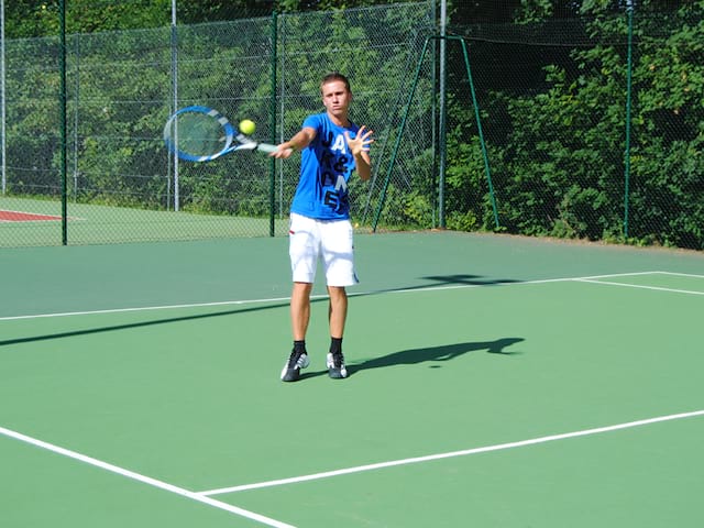 Adolescente jouant au tennis cet été durant un stage sportif