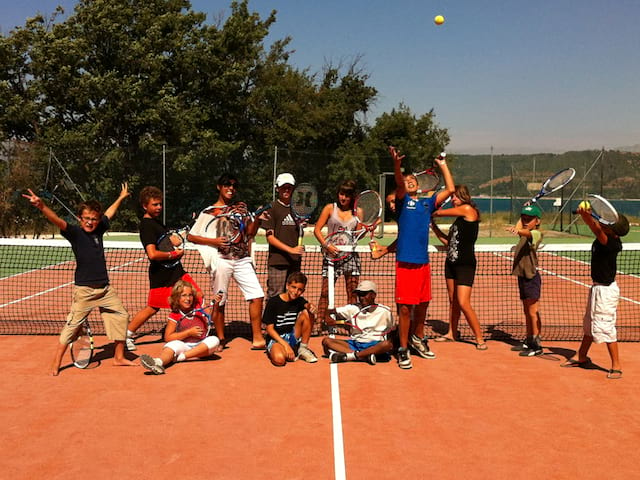 groupe d'enfants et ados jouant au tennis cet été en stage sportif