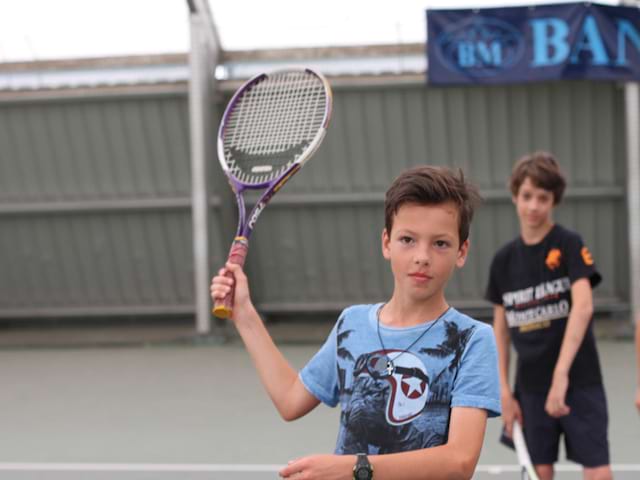 enfant en stage de tennis pour se perfectionner cet été