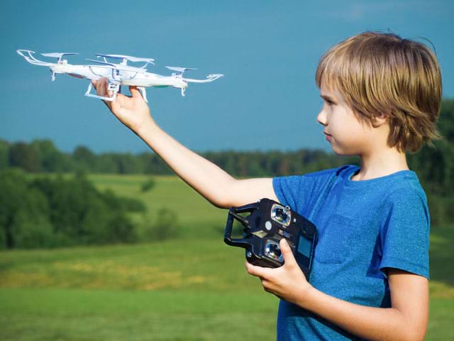 Enfant apprenant à faire voler un drone en colonie de vacances à la campagne