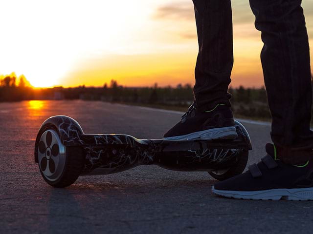 Adolescent faisant de l'hoverboard en fin de journée en colonie de vacances multiactivités cet été