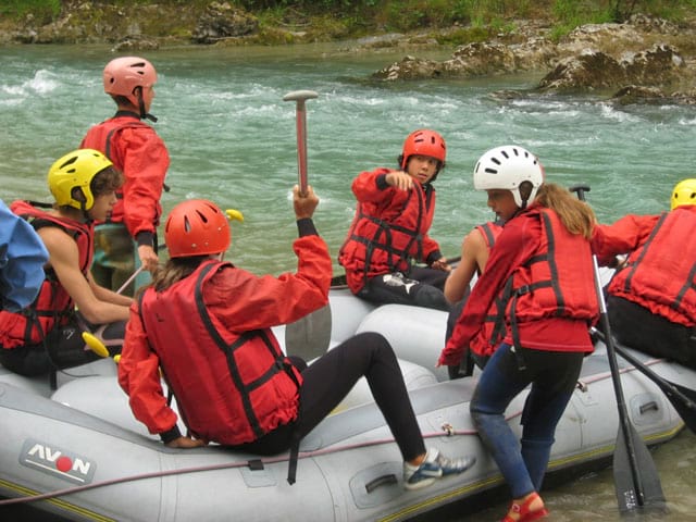 Adolescents faisant du rafting en colonie de vacances à la montagne