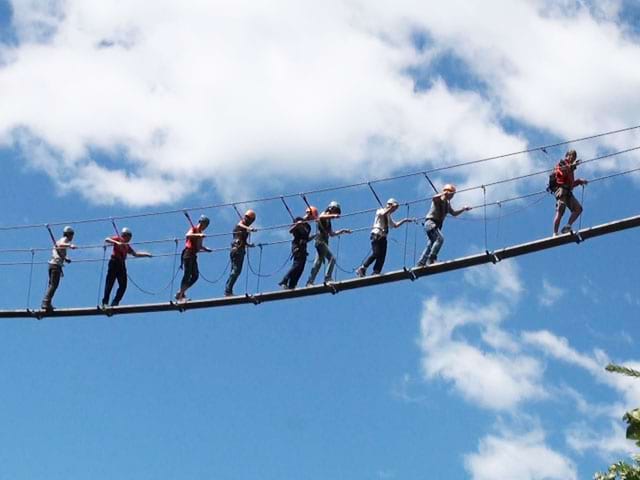 Groupe d'enfants sur un pont dans les airs en colonie via ferrata 