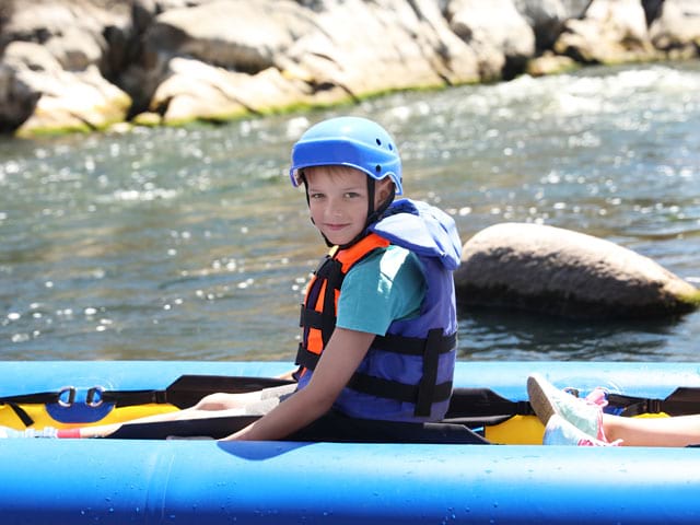 Enfant faisant du canoe kayak en colonie de vacances à la montagne