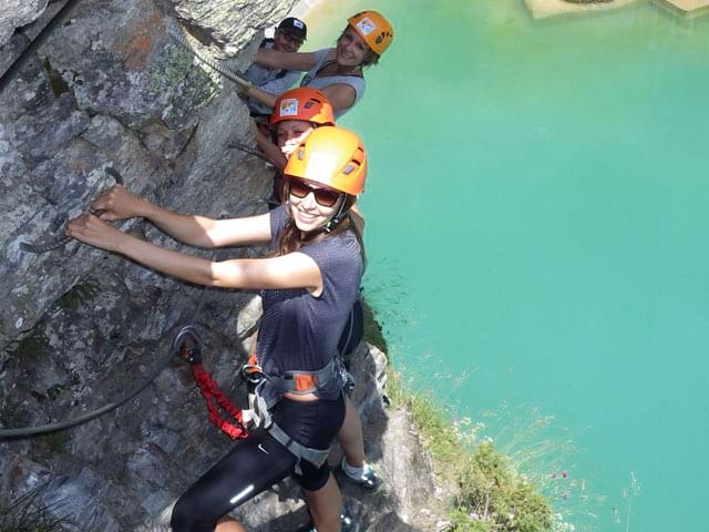 Adolescents faisant de la via ferrata en colonie de vacances à la montagne