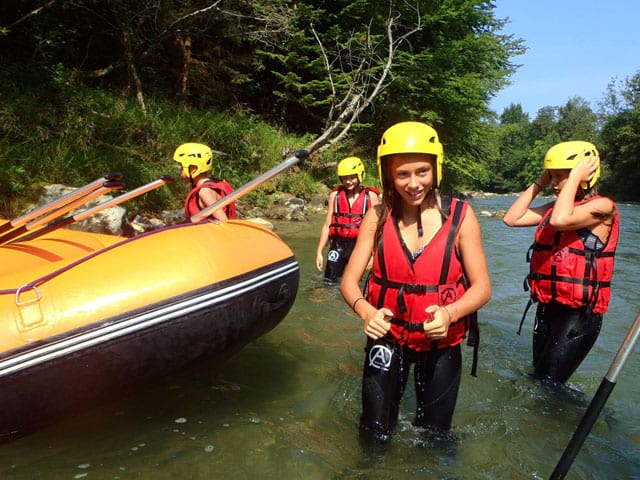 Adolescents dans l'eau faisant du canoe kayak en colonie de vacances