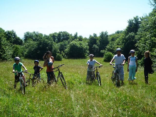 Adolescents et enfants en randonnée à vélo en colonie de vacances d'été à courchevel