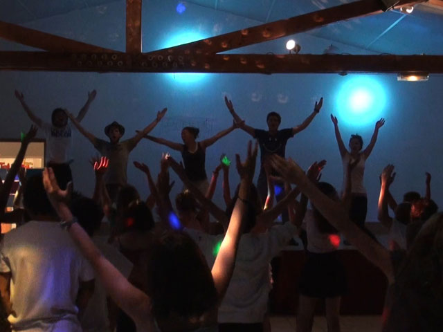 Groupe d’enfants en boom en colonie de vacances dansant avec leurs animateurs de colo été