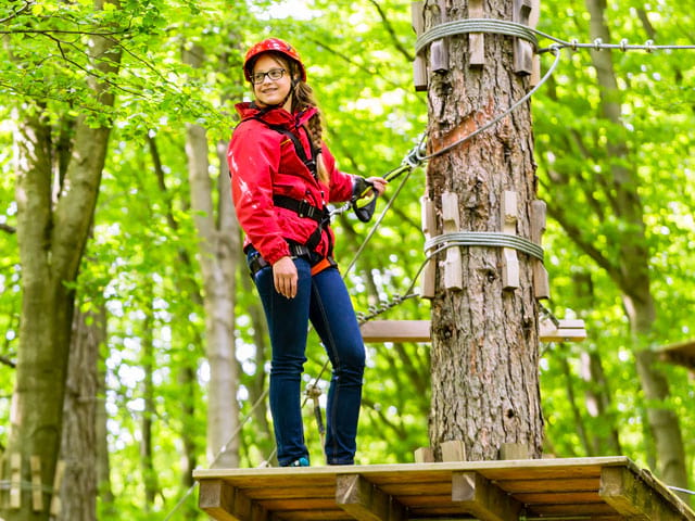 jeune fille faisant de l'accrobranche en colonie de vacances