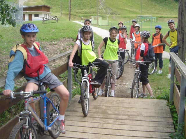 Groupe d'enfants à vélo en colonie de vacances montagne