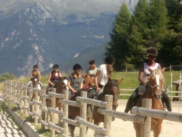 Groupe d'adolescents à cheval en colonie de vacances équitation à la montagne été